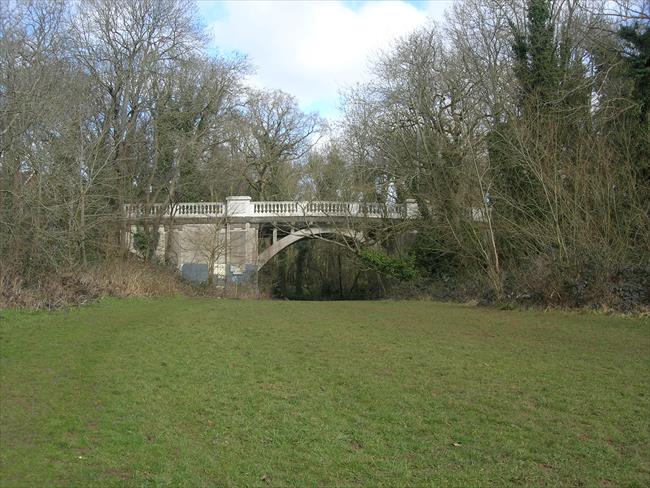 Stone bridge over Trym. Exit flight of steps on left just before bridge.