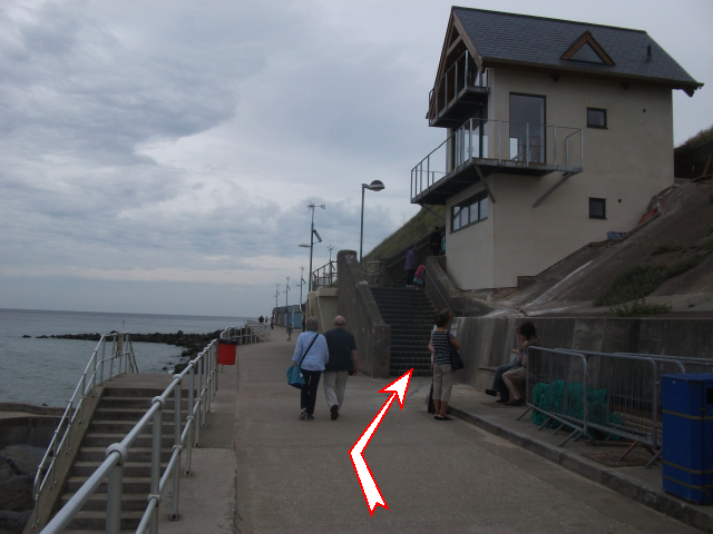 Photo 4.  Leave the promenade and ascend these steps.  Follow the coast path East, walking over Beeston Bump and down towards a large static caravan site.  Turn right before this and follow the coast path inland.